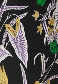 Blommönstrad tyg med löv och blommor i lila, gult och grönt mot en svart bakgrund, som visar ett texturerat mönster.