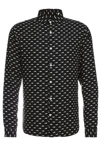 Camisa de manga larga negra con un patrón de estampado animal blanco repetido, con cuello y cierre de botones en el frente. Fabricada con tejido suave.