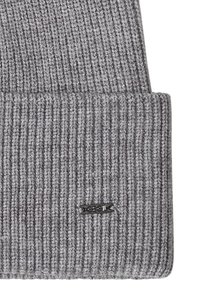 Bonnet gris en maille côtelée avec revers plié et petite étiquette métallique noire indiquant « "CECIL" » sur le revers.