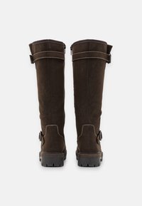 Καφέ σουέτ μπότες μέχρι το γόνατο με ρυθμιζόμενες λωρίδες, ραφές και ανθεκτική σόλα για πρόσφυση. Ανθεκτικός και λειτουργικός σχεδιασμός.