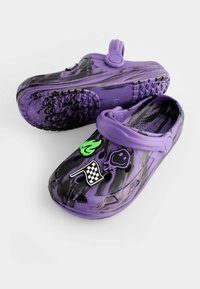 Violetti crocs ar melnā marmora rakstu, ar zaļu liesmu, melnu smaidošu seju un šaha karoga rotājumiem. Tekstūrēti zolei, lai nodrošinātu saķeri.