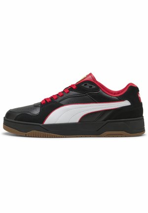 Black leather sneakers featuring red laces and accents, white side stripe, and gum rubber sole with a flat design. Notable branding on tongue.