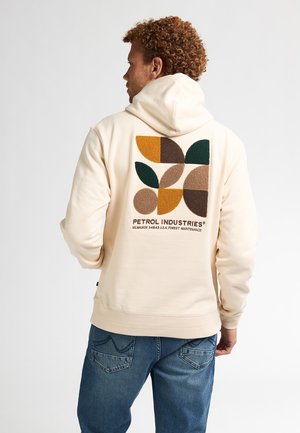 Haut à capuche beige avec un motif de feuilles multicolores texturé et le texte "PETROL INDUSTRIES®" au dos. Matière douce avec une coupe décontractée.