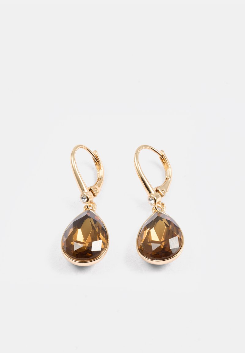 Brincos pendentes em tom dourado com cristais castanhos em forma de pêra com superfícies facetadas e pequenas pedras claras de destaque perto do gancho.