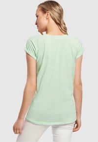 Merchcode LOVE YOURSELF FIRST EXTENDED SHOULDER - T-shirts med print - neo mint