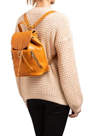 Sac à dos en cuir de couleur orange vif, avec une fermeture à cordon, deux poches zippées à l'avant et des bretelles réglables. Détail de surface texturé.