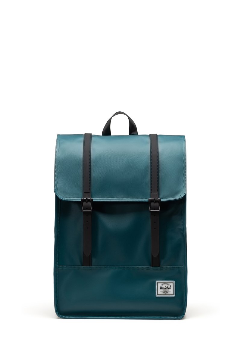 Teal backpack with a glossy finish, featuring two black leather shoulder straps and a flap closure with metal buckles. Includes a front pocket.