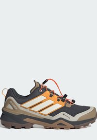 Παπούτσι πεζοπορίας Terrex με πάνω μέρος από μαύρο ύφασμα με πορτοκαλί και μπεζ διακοσμητικά, κλείσιμο με κορδόνια και ανθεκτική καφέ εξωτερική σόλα από καουτσούκ.