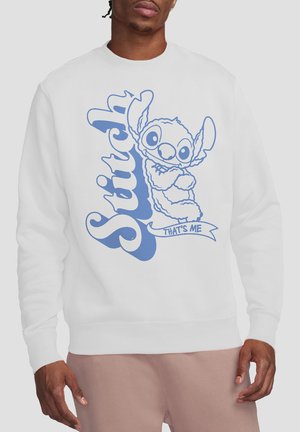 White sweatshirt featuring a blue cartoon graphic of Stitch, arms crossed, with the text "Stitch" and "That's Me" beneath.