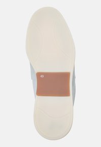 Schoenzool met een witte rubberen basis en een bruine accent. Bevat gestructureerde patronen en een maatindicator (43) op het bruine gedeelte.