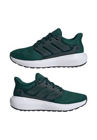 Zapatillas deportivas de malla verde con un diseño ligero, que incluyen tres franjas negras, una entresuela blanca acolchada y una suela de goma texturizada.