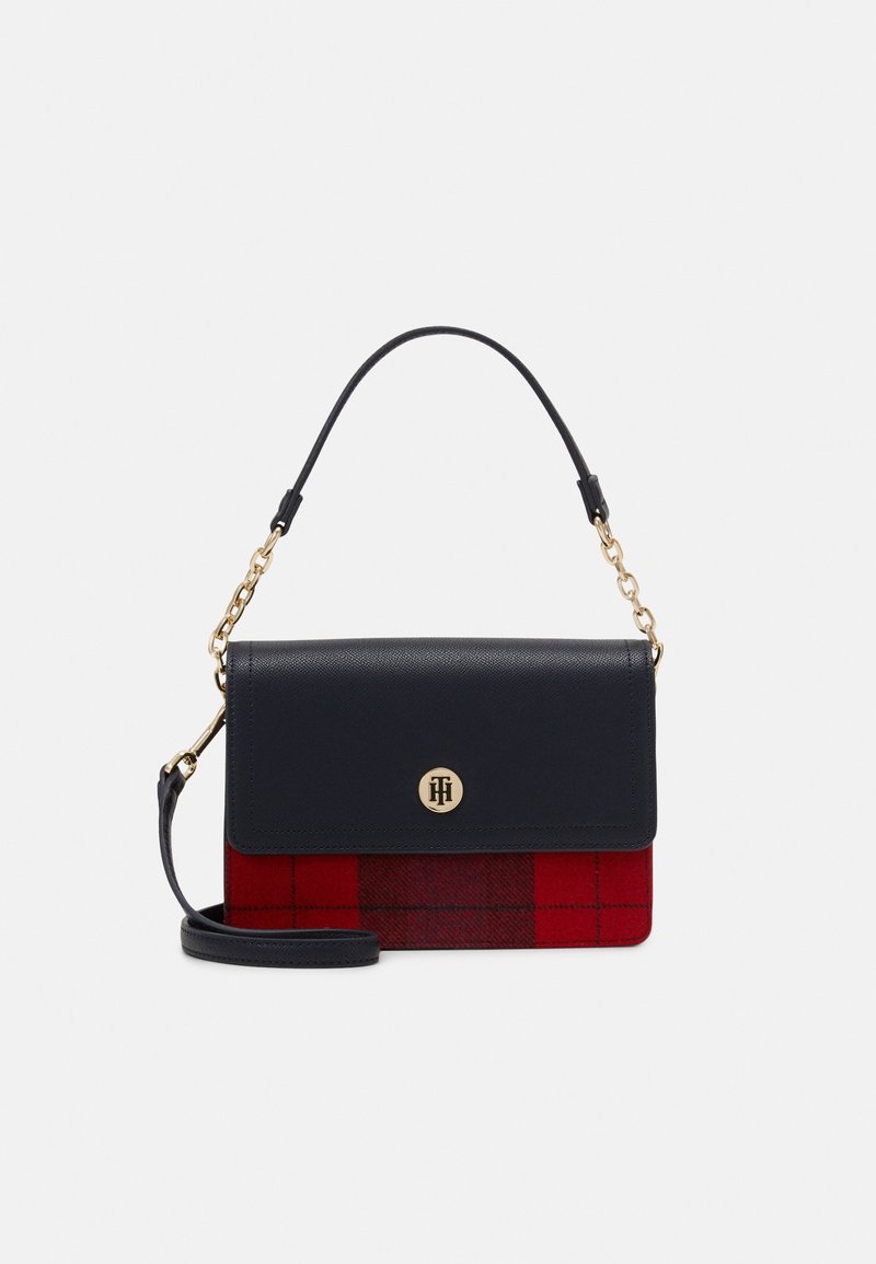Sac à épaule en cuir noir avec un fond à carreaux rouges, quincaillerie dorée et une bandoulière amovible. Il dispose d'un rabat avant et d'un détail de logo.