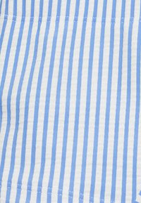 Tela a rayas con franjas verticales alternas en azul claro y blanco, que muestra una textura suave y un patrón consistente.