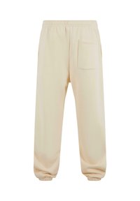 Pantalones de chándal beige con cintura y puños elásticos, que presentan un gran bolsillo de parche en el lado derecho delantero.