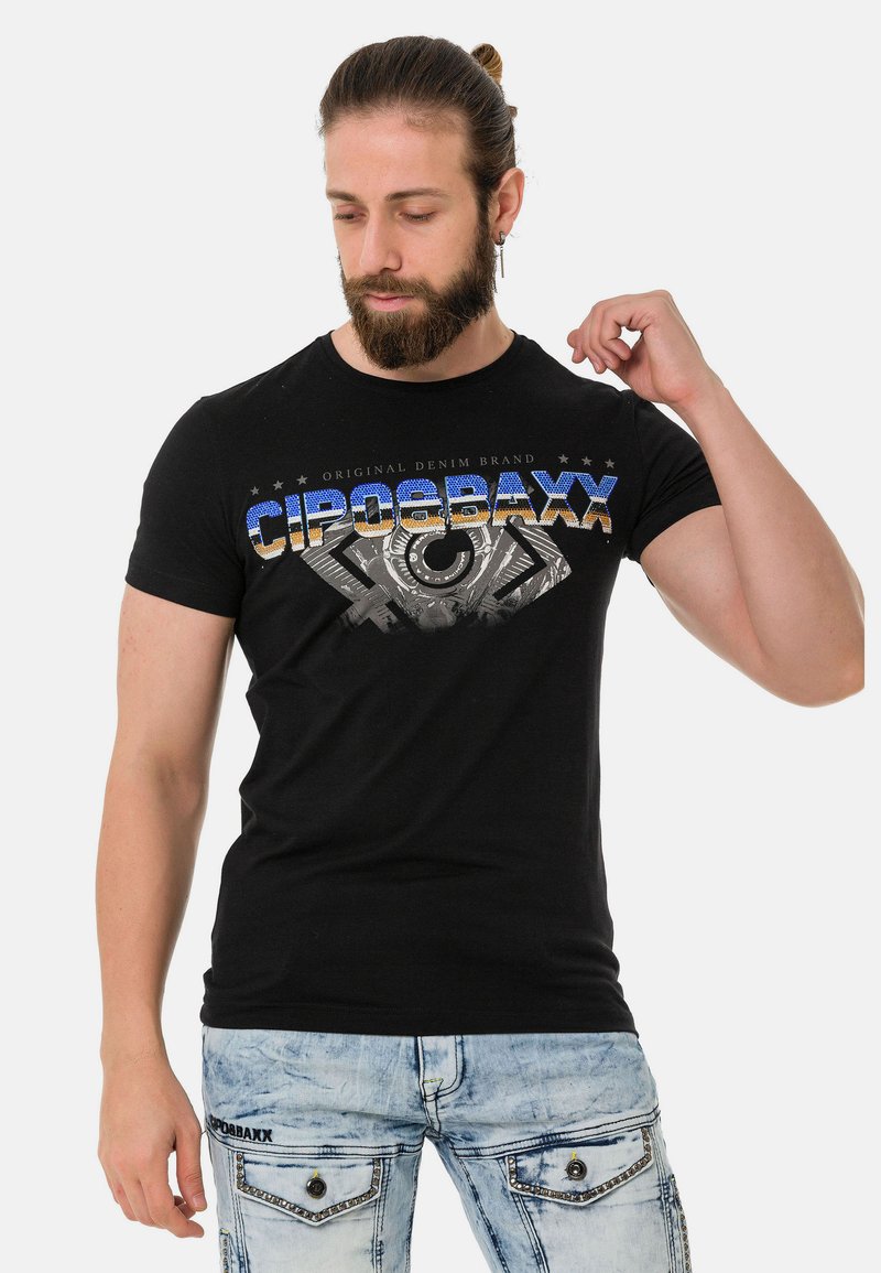 Schwarzes Baumwoll-T-Shirt mit einem Grafikdruck, der den Markennamen "CIPOBAXX" in Blau und Orange zeigt, vor einem strukturierten grauen Design.