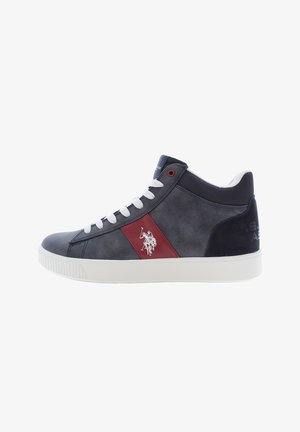 Zapatillas altas en gamuza azul marino y gris, con cordones blancos, un panel de acento rojo y un emblema en el lateral con una suela blanca.