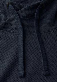 Námořnický modrý mikina s kapucí z texturované látky, se stahovací šňůrkou a kovovými očky. Vzor má jemný mřížkovaný design.