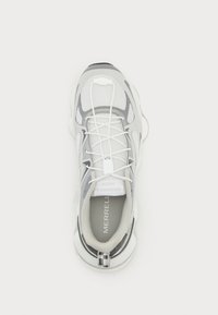 Shoe sportiv gri și alb, cu un material superior din plasă, design cu șireturi, guler captusit și o talpă texturată cu un accent rayat aproape de călcâi.