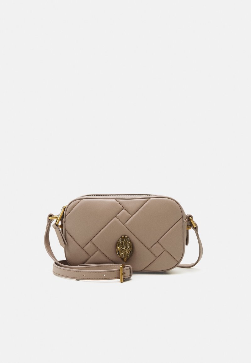 Béžová prošívaná crossbody taška se zlatými prvky, vyznačující se dekorativním akcentem ve tvaru ruky a odnímatelným ramenním popruhem. Obdélníkový tvar.