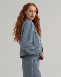 Giacca di jeans a righe con design corto, dotata di maniche lunghe, chiusura a bottoni e tasche. Indossata con pantaloni a righe coordinati.