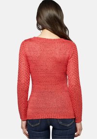 Czerwony sweter z dzianiny z długimi rękawami, o fakturowanym splocie i luźnym kroju. Widok z tyłu ukazuje szerszy dekolt i delikatne żebrowanie na dole.