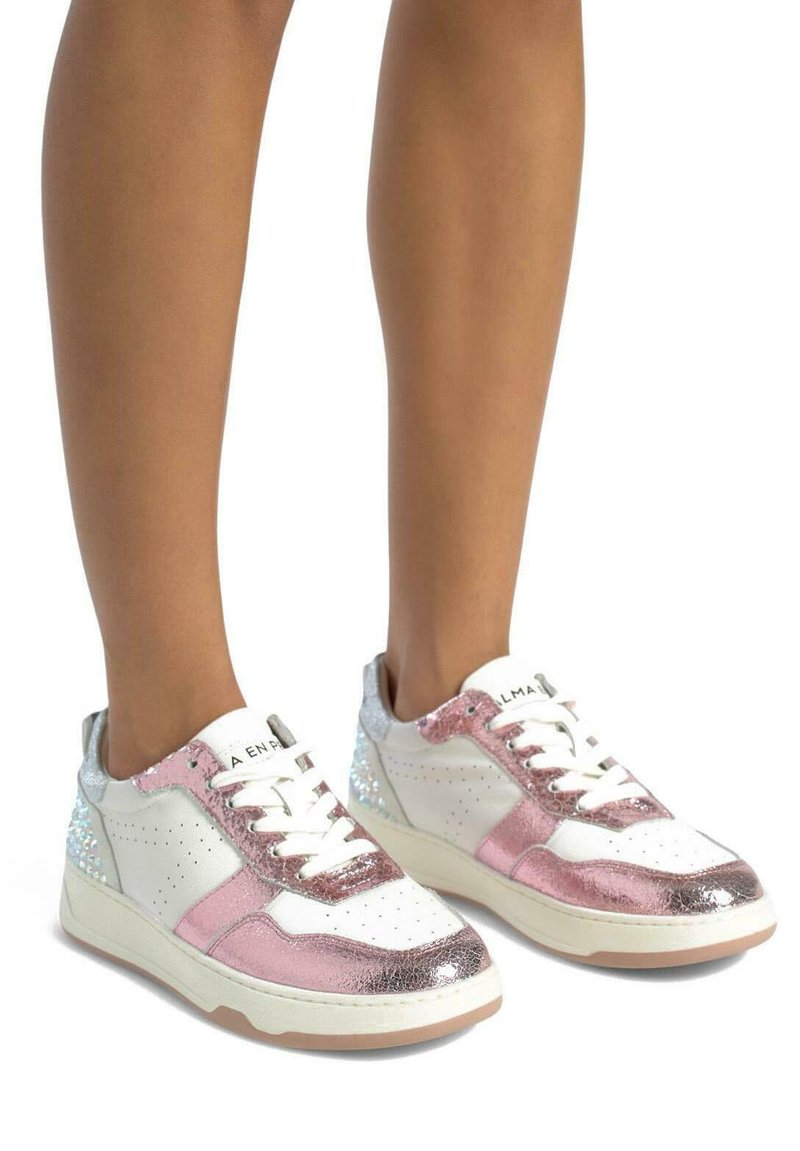 Zapatillas con materiales metálicos en blanco, rosa y plata. Punta redondeada, diseño perforado en los laterales y acentos brillantes en los talones.
