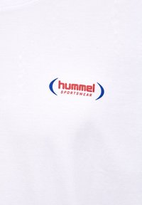 Logo rouge "hummel SPORTSWEAR" centré entre deux crochets bleus courbés sur fond de tissu blanc.