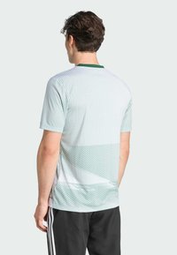 Majica kratkih rukava u zelenoj i bijeloj boji sa uzorkom, atletskoga stila, s okruglim izrezom, koja se odlikuje teksturiranim oblikom i slobodnim krojem.