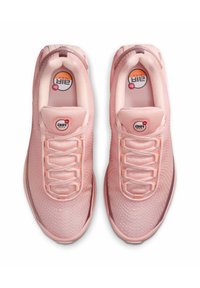 Zapatillas de malla rosa claro con un empeine texturizado, cordones y una unidad de amortiguación de aire visible en la suela. Logos circulares en la lengua.