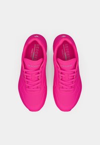 Svijetlos roze Skechers tenisice s vezicama, širokog kroja i ulošcima od memorijske pjene koja se hladi, prikazane odozgo na bijeloj podlozi.