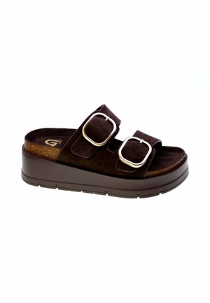 Sandalo con fascia di colore marrone scuro con due larghe cinghie e grandi fibbie argentate su una suola spessa platform.