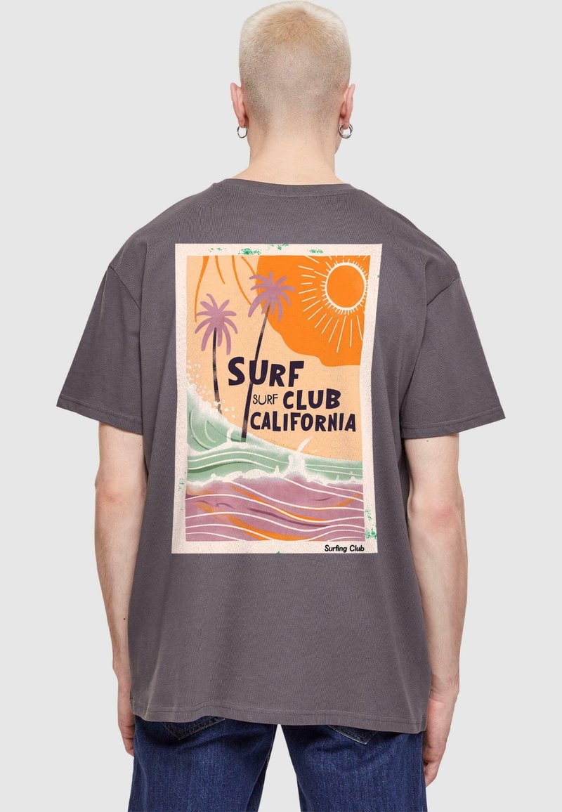 Grå T-shirt med korte ærmer, der har et farverigt surf-tema grafisk design på ryggen med palmer og bølger, trykt design detaljer.