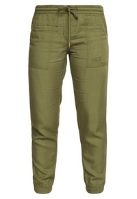 Olivgröna joggerbyxor med elastisk midja och dragsko. Har sidofickor och en liten logotyp på vänster lår. Slät textur.