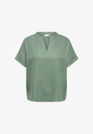 Gaiši zaļa īsroku blūze ar V veida kakla izgriezumu un uzvilktiem aproču galiem, izgatavota no vieglas teksturētas auduma.