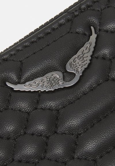 Portefeuille en cuir noir avec une texture matelassée, arborant un emblème d'aile métallique brillant. Détail zippé en haut.