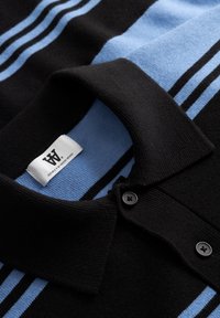 Polo noir avec des rayures bleu clair et bleu marine, doté d'un col, d'une patte à trois boutons, et d'une étiquette marquée "Double by Wood Wood".