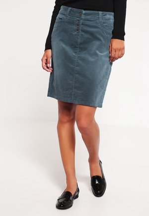 Tealfarbene Jeans-Bleistiftrock mit vorderem Knopfverschluss, Seitentaschen und glatter Textur, kombiniert mit schwarzen Lackschuhen.