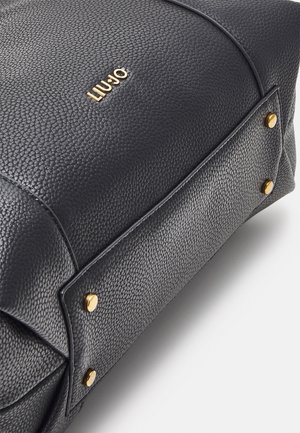 Zwarte leren handtas met een gestructureerd oppervlak, gouden hardware en een opvallend logo. Accenten zijn gouden studs aan de zijkanten.