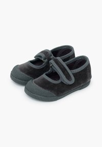 Zapatos de terciopelo gris con punta redonda, suela de goma plana y una correa de velcro a lo largo del empeine. Presentan una superficie texturizada y costuras en contraste.