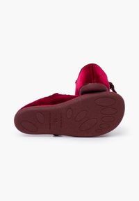 Chausson en velours rouge avec un dessus doux et une semelle en caoutchouc dotée d'un motif texturé pour une meilleure adhérence. Fabriqué en Espagne.