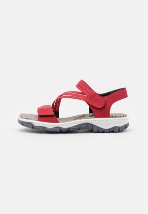Sandalia roja de punta abierta con correas ajustables, plantilla acolchada gris y suela gruesa texturizada blanca y negra.