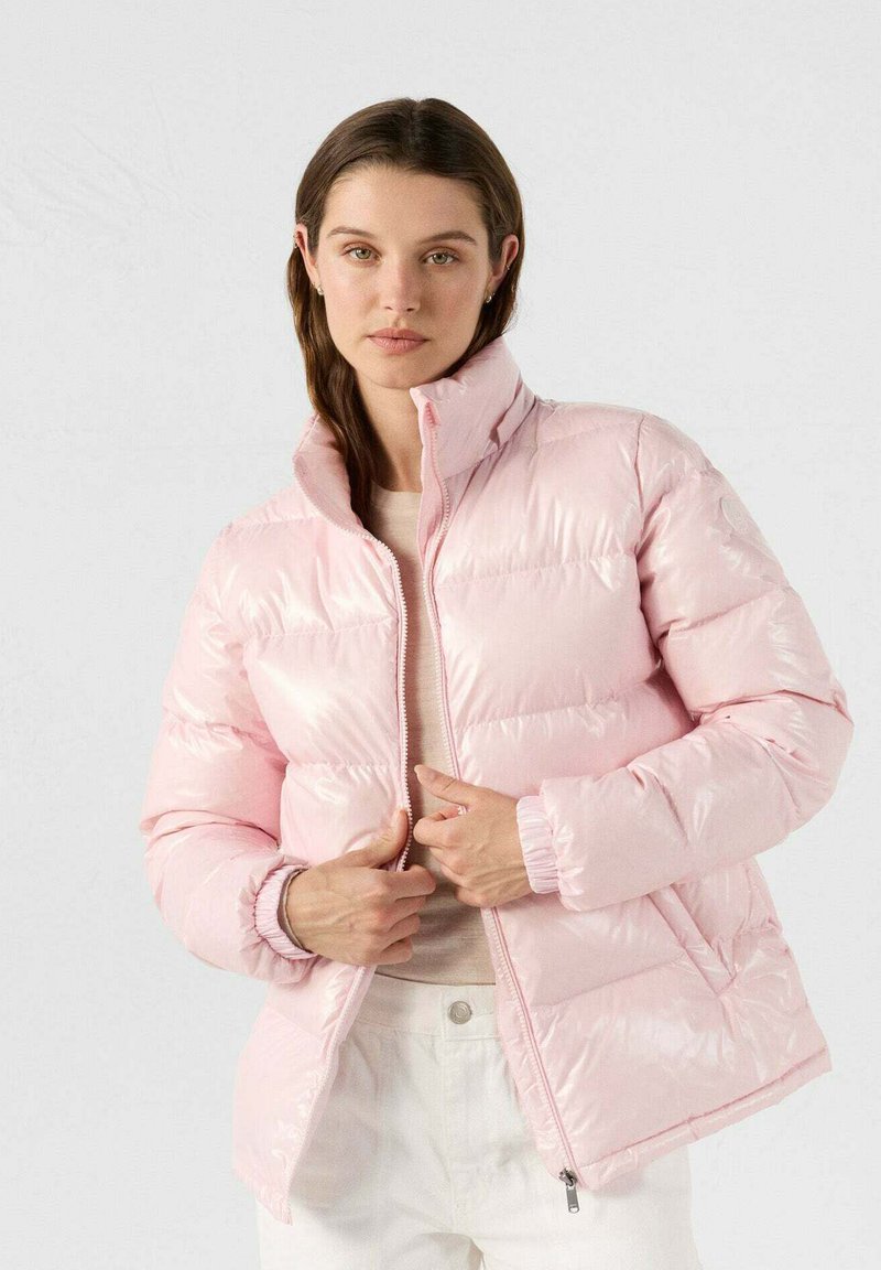 Giacca rosa puffosa con colletto alto, chiusura a zip e polsini elastici. Realizzata in materiale lucido e imbottito, progettata per calore e comfort.