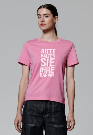 Rosa Kurzarm-T-Shirt aus Baumwolle mit weißem Text "BITTE HALTEN SIE IHRE BAPPM" in einer fetten, vertikalen Anordnung.