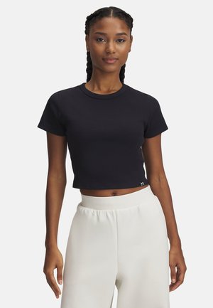 Svart ribbad croptop med korta ärmar och rund halsringning, kombinerad med vita högmidjade byxor i lös passform. Diskret logotypdetalj vid fållen.