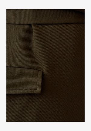 Temno rjava tkanina z diagonalno rebrasto teksturo. Vključuje horizontalno žep z šivanim robom in gladko površino.