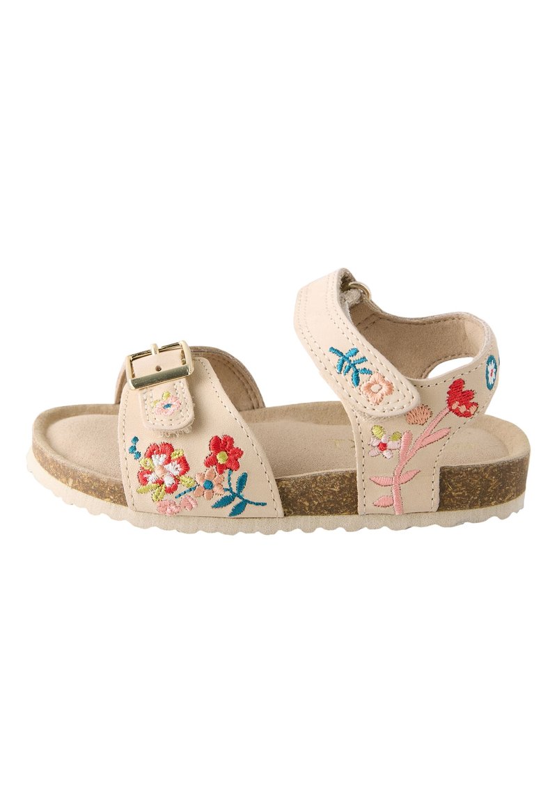 Sandale enfant beige avec broderie florale, boucle réglable et brides Velcro, semelle imitation liège et semelle extérieure en caoutchouc texturé.