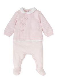 Conjunto para bebé en color rosa que incluye una camiseta texturizada con un cuello blanco y tres lazos decorativos, combinado con pantalones de pie rosa a juego.