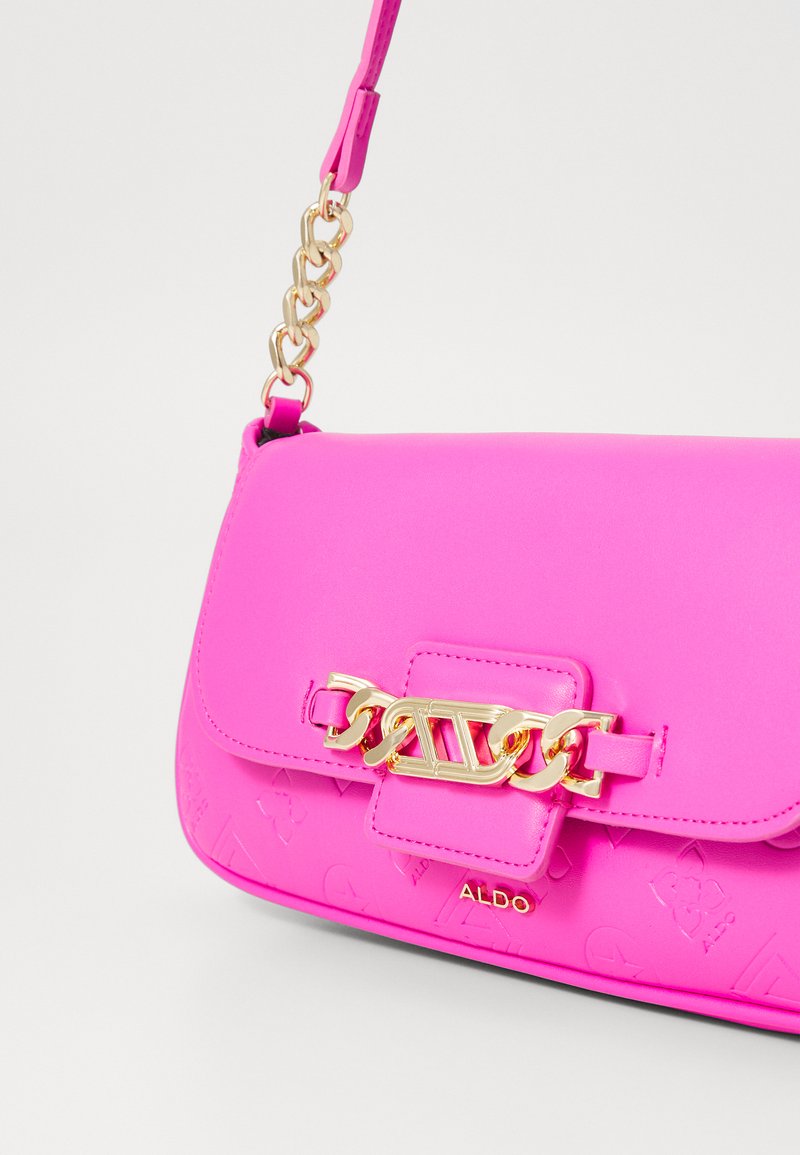 Borsa sintetica rosa con hardware dorato, caratterizzata da un dettaglio decorativo a catena e un motivo logo testurizzato sul davanti.