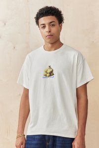 Light cream cotton t-shirt featuring a graphic of a burlap sack with green fruit and the text "Bitter Sweet" in blue. Short sleeves and relaxed fit.