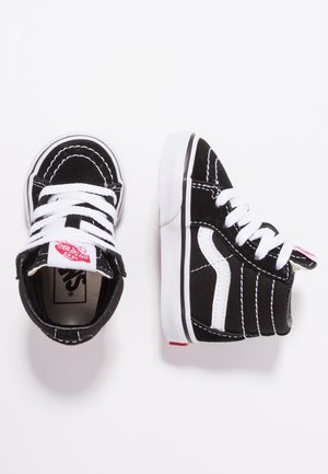 Zwarte suède hoge sneakers met witte accenten, voorzien van witte veters, stikseldetails en een rood logolabel op de tong.